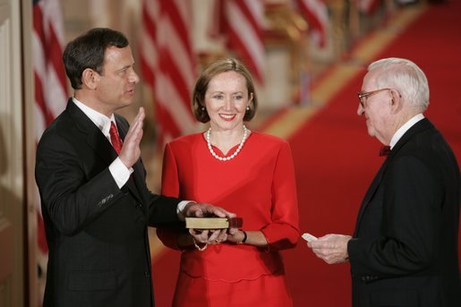 Judge John G. Roberts is sworn-in as the 17th Chief Justice of the United States by Associated Supreme Court Justice John Paul Stevens, Thursday, Sept. 29, 2005 in the East Room of the White House in Washington. Judge Roberts' wife Jane is seen holding the Bible. White House photo by Paul Morse