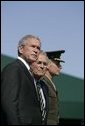 President George W. Bush stands with Defense Secretary Donald Rumsfeld and newly sworn-in Chairman of the Joint Chiefs of Staff, U.S. Marine General Peter Pace, Friday, Sept. 30, 2005 at the Armed Forces Farewell Tribute in Honor of General Richard B. Myers and Armed Forces Hail in Honor of General Pace at Fort Myer in Ft. Myers, Va. White House photo by Shealah Craighead