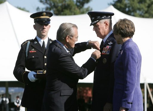 Defense Secretary Donald Rumsfeld pins a medal on General Richard B Myers, as Myers' wife, Mary Jo Myers, looks on Friday, Sept. 30, 2005, during The Armed Forces Farewell Tribute in Honor of General Richard B. Myers and the Armed Forces Hail in Honor of General Peter Pace at Fort Myer's Summerall Field in Ft. Myer, Va. White House photo by David Bohrer