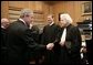 President George W. Bush shakes hands with U.S. Supreme Court Associate Justice Sandra Day O' Connor, during his visit to the U.S. Supreme Court for the investiture ceremony for U.S. Chief Justice John Roberts, seen background-center, Monday, Oct. 3, 2005 in Washington. Associate Justice John Paul Stevens is seen at left. White House photo by Eric Draper