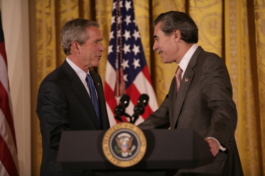 President George W. Bush thanks U.S. Commerce Secretary Carlos Gutierrez for his introduction in the East Room of the White House, Friday, Oct. 7, 2005, as President Bush prepares to address remarks in celebration of Hispanic Heritage Month. President Bush also honored recipients of the President's Volunteer Service Awards at the event. White House photo by Eric Draper