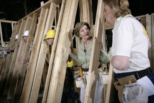 Laura Bush helps push a support wall into place, Tuesday, Oct. 11, 2005, while visiting a Habitat for Humanity building site in Covington, La., where homes are being built for victims of Hurricane Katrina. White House photo by Eric Draper