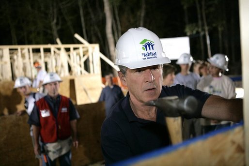 President George W. Bush dons a hard hat as he joins volunteers at a Habitat for Humanity building site Tuesday, Oct. 11, 2005, in Covington, La. White House photo by Eric Draper