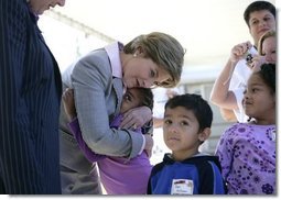 Laura Bush gives a hug to a student at Delisle Elementary School in Pass Christian, Miss., Tuesday, Oct. 11, 2005, as the school reopened for the first time since the area was struck by Hurricane Katrina.  White House photo by Eric Draper