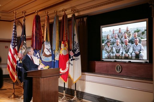 President George W. Bush gestures as he speaks with troops, from the U.S. Army's 42nd Infantry Division serving in Iraq, via video teleconference from the Eisenhower Executive Office Building in Washington, Thursday, Oct. 13, 2005. White House photo by Paul Morse