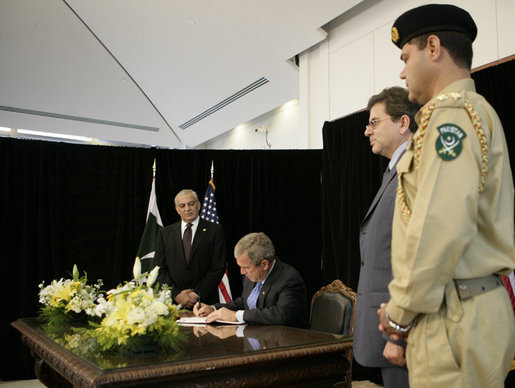 President George W. Bush signs a book of condolences, Friday, Oct. 14, 2005 at the Pakistan Embassy in Washington, to express the condolences of the American people for those who suffered as a result of the recent earthquake that struck Pakistan. Pakistan's Ambassador Jehangir Karamat is seen looking on at left. White House photo by Eric Draper