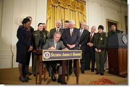 President George W. Bush is joined by legislators, cabinet members and law enforcement officials, Tuesday, Oct. 18, 2005 in the East Room of the White House, as he signs the Homeland Security Appropriations Act for fiscal year 2006.  White House photo by Paul Morse