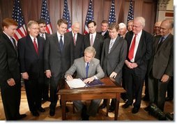 President George W. Bush is joined by legislators, Wednesday, Oct. 26, 2005 at the Eisenhower Executive Office Building in Washington, as he signs the Protection of Lawful Commerce in Arms Act.  White House photo by Paul Morse