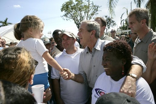 President George W. Bush greets local residents lined up at a food and water distribution center, Thursday, Oct. 27, 2005, in the hurricane damaged area of Pompano Beach, Fla. White House photo by Eric Draper