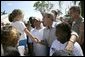 President George W. Bush greets local residents lined up at a food and water distribution center, Thursday, Oct. 27, 2005, in the hurricane damaged area of Pompano Beach, Fla.  White House photo by Eric Draper