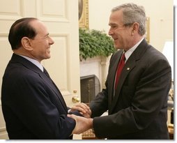 President George W. Bush welcomes Italian Prime Minister Silvio Berlusconi to the Oval Office at the White House, Monday, Oct. 31, 2005 in Washington.  White House photo by Eric Draper