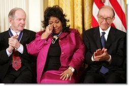 Queen of Soul Aretha Franklin wipes a tear after being honored with the Presidential Medal of Freedom Wednesday, Nov. 9, 2005, during ceremonies at the White House. Looking on are fellow recipients Robert Conquest, left, and Alan Greenspan.  White House photo by Paul Morse
