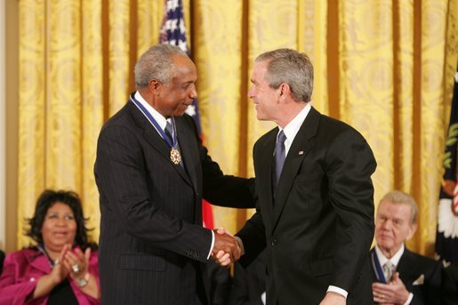 President George W. Bush presents the Presidential Medal of Freedom to baseball legend Frank Robinson in the East Room Wednesday, Nov. 9, 2005. Winning the Most Valuable Player awards in the National and American Leagues, he achieved the American League Triple Crown in 1966. Mr. Robinson became baseball's first African-American manager. White House photo by Paul Morse