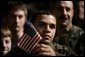 An unidentified member of the U.S. Armed Forces holds an American flag as he listens to the President’s remarks on the War on Terror, Monday Nov. 14, 2005, at Anchorage’s Elmendorf Air Force Base. The stop marked the first on a seven-day trip to Asia by the President and Mrs. Bush. White House photo by Eric Draper