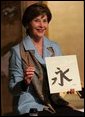 Mrs. Laura Bush holds up her calligraphy of a Chinese character, ei, meaning eternity, during a lesson Wednesday, Nov. 16, 2005, at the Suchiya-cho Townhouse in Kyoto, Japan. White House photo by Shealah Craighead