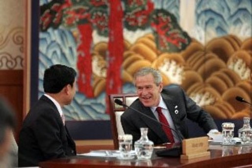 President George W. Bush and Thailand Prime Minister Thaksin Chinnawat share a laugh Friday, Nov. 18, 2005, during an opening session at the two-day, 2005 APEC summit in Busan, Korea. White House photo by Paul Morse