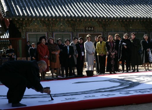 An artist paints calligraphy for the spouses of APEC leaders Friday, Nov. 18, 2005, during their visit to the Beomeosa Temple in Busan, Korea. White House photo by Shealah Craighead