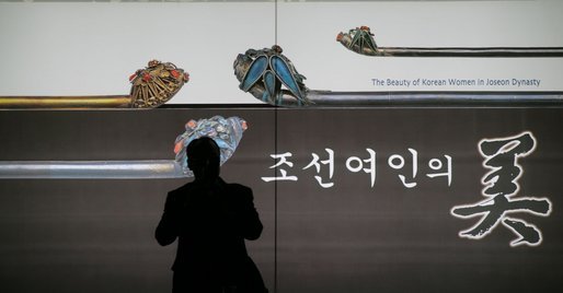A spectator is silhouetted as he takes a photo from a doorway at the Busan Museum in Busan, Korea, where Laura Bush was visiting Saturday morning. White House photo by Shealah Craighead