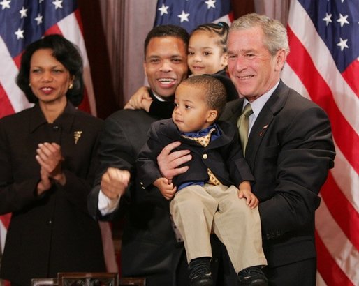 President George W. Bush is seen Thursday, Dec. 1. 2005 in the Eisenhower Executuive Office Building in Washington, as he poses for photos with U.S. Rep. Jesse Jackson Jr. and his children, Jesse Jackson III and Jessica, following the signing of H.R. 4145, to Direct the Joint Committee on the Library to Obtain a Statue of Rosa Parks, which will be placed in the US Capitol's National Statuary Hall. U.S. Secretary of State Condoleezza Rice is seen at left. White House photo by Paul Morse
