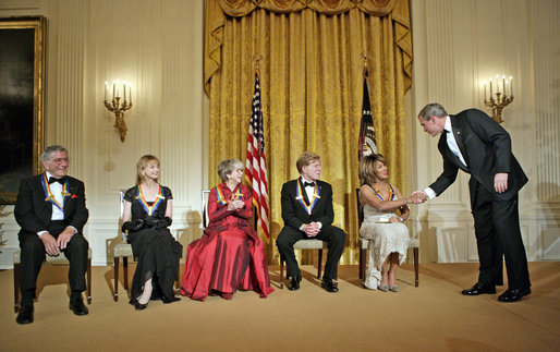 President George W. Bush congratulates Tina Turner during a reception for the Kennedy Center Honors in the East Room of the White House Sunday, Dec. 4, 2005. From left, the honorees are singer Tony Bennett, dancer Suzanne Farrell, actress Julie Harris, actor Robert Redford and singer Tina Turner. White House photo by Eric Draper