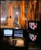 The President and Mrs. Bush are seen on a television monitor Sunday, Dec. 11, 2005, as they enjoyed the festivities during the 24th Annual Christmas in Washington as it was videotaped at the National Building Museum. White House photo by Shealah Craighead