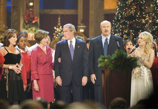 President and Mrs. Bush sing "Hark, the Herald Angels Sing!" along with Dr. Phil McGraw, his wife Robin, left, and Carrie Underwood, right, during the 24th Annual Christmas in Washington at the National Building Museum in downtown Washington D.C. White House photo by Shealah Craighead