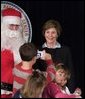 Laura Bush poses for a photo as she visits with children at the Naval and Marine Corps Reserve Center in Gulfport, Miss., Monday, Dec. 12, 2005, where she showed them a White House holiday video featuring the Bush's dogs "Barney and Miss Beazley." White House photo by Shealah Craighead