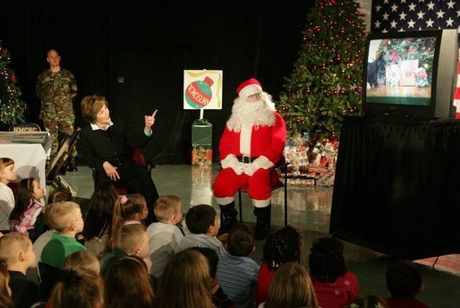 Laura Bush visits with children at the Naval and Marine Corps Reserve Center in Gulfport, Miss., Monday, Dec. 12, 2005, showing them the White House holiday video, 'A Very Beazley Christmas' featuring the Bush's dogs, Barney and Miss Beazley. White House photo by Shealah Craighead