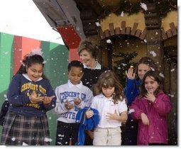 Laura Bush and children from New Orleans neighborhoods react to a downpour of fake snow flakes, Monday Dec. 12, 2005 at the Celebration Church in Metairie, La., during a Toys for Tots event.  White House photo by Shealah Craighead