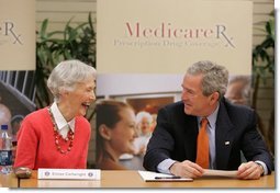 President George W. Bush smiles at 85-year-old Eloise Cartwright as he joins the residents of Greenspring Village Retirement Community and others for a roundtable discussion on the Medicare Prescription Drug Benefit Tuesday, Dec. 13, 2005, in Springfield, Va.  White House photo by Paul Morse