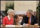 President George W. Bush smiles at 85-year-old Eloise Cartwright as he joins the residents of Greenspring Village Retirement Community and others for a roundtable discussion on the Medicare Prescription Drug Benefit Tuesday, Dec. 13, 2005, in Springfield, Va.  White House photo by Paul Morse