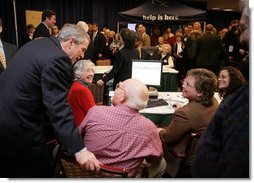 President Bush leans over to view a computer screen as he visits with participants Tuesday, Dec. 13, 2005, at the Medicare Prescription Drug Educational and Enrollment Event at the Greenspring Village Retirement Community in Springfield, Va.  White House photo by Paul Morse