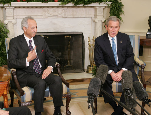 President George W. Bush is joined by Samir Sumaidaie, Iraq Ambassador to the United Nations, in the Oval Office Friday, Dec. 16, 2005. The Ambassador holds up his finger, dyed purple to signify his vote yesterday in his country's parliamentary elections. White House photo by Paul Morse