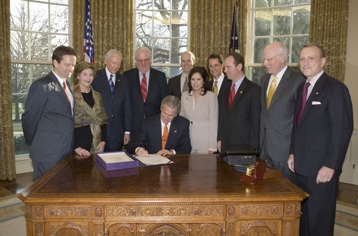 Accompanied by Laura Bush and legislators, President George W. Bush signs H.R. 3402, The Violence Against Women and Department of Justice Reauthorization Act of 2005, during a ceremony in the Oval Office Thursday, Jan. 5, 2005. The bill is a comprehensive package that reauthorizes Department of Justice programs to combat domestic violence, dating violence, sexual assault, and stalking. White House photo by Paul Morse