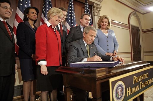 President George W. Bush signs H.R. 972, the Trafficking Victims Protection Reauthorization Act of 2005, in the Dwight D. Eisenhower Executive Office Building Tuesday, Jan. 10, 2006. The bill directs the U.S. Agency for International Development (USAID), the State Dept., and Dept. of Defense to incorporate anti-trafficking and protection measures for vulnerable populations, particularly women and children, into their post-conflict and humanitarian emergency assistance and program activities. White House photo by Eric Draper