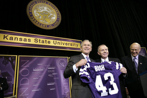 President George W. Bush receives a Kansas State Football jersey from University President Jon Wefald, center, with Kansas Senator Pat Roberts before delivering remarks on the global War on Terror at Kansas State University in Manhattan, Kan., Monday, Jan. 23, 2006. White House photo by Eric Draper