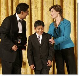 Laura Bush congratulates Jose Fernando Salas, left, and Carlos Gabriel Pascual from the Art and Children Program of Veracruz, Mexico, at their award presentation Wednesday, Jan. 25, 2006 in the East Room of the White House, during the President's Committee on the Arts and the Humanities 2006 Coming Up Taller Awards ceremony.  White House photo by Shealah Craighead
