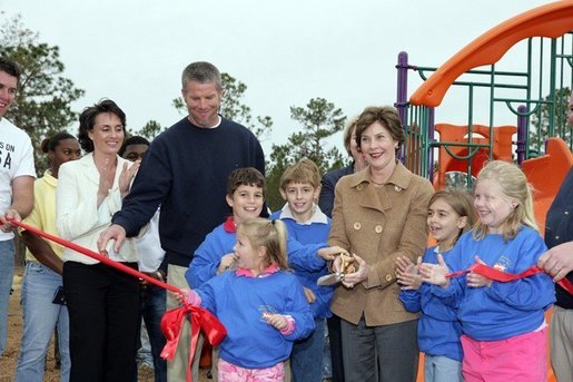 Laura Bush attends a ribbon cutting ceremony with football star Brett Favre and his wife, Deanna, left, at the Kaboom Playground, built at the Hancock North Central Elementary School in Kiln, Ms., Wednesday, Jan. 26, 2006, during a visit to the area ravaged by Hurricane Katrina. White House photo by Shealah Craighead