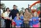 Laura Bush attends a ribbon cutting ceremony with football star Brett Favre and his wife, Deanna, left, at the Kaboom Playground, built at the Hancock North Central Elementary School in Kiln, Ms., Wednesday, Jan. 26, 2006, during a visit to the area ravaged by Hurricane Katrina. White House photo by Shealah Craighead