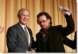 President George W. Bush shakes hands with Bono after the musician spoke Thursday morning, Feb. 2, 2006, during the National Prayer Breakfast. President Bush called the rock star a "doer" and a "good citizen of the world."  White House photo by Paul Morse