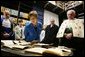 Laura Bush looks at books dating to the 1500’s during a tour of the Ancient Library at the University of Turin guided by Paolo Novaria, Archives, left, and Enrico Artifoni, right, Saturday, Feb. 11, 2006, in Turin, Italy. White House photo by Shealah Craighead