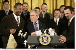 President George W. Bush is presented with a Chicago White Sox jacket and baseball jersey, Monday, Feb. 13, 2006 by White Sox players Jermaine Dye, left, and Paul Konerko in the East Room of the White House, where President Bush honored the 2005 World Series Champions. White House photo by Eric Draper