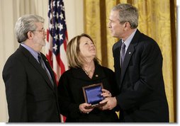 President George W. Bush presents a National Medal of Technology, Monday, Feb. 13, 2006 to George Lucas, left, and Chrissie England, of Industrial Light and Magic of San Francisco, Calif., during ceremonies in the East Room of the White House.  White House photo by Eric Draper