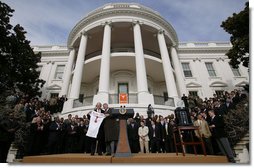 President George W. Bush holds up a University of Texas Longhorns jersey with head football coach Mack Brown, Tuesday, Feb. 14, 2006 on the South Lawn of the White House, during ceremonies to honor the 2005 NCAA Football Champions. White House photo by Paul Morse