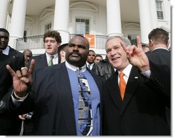 President George W. Bush poses with University of Texas Longhorns assistant coach Jeff 'Mad Dog' Madden, as they give the 'Hook Em Horns' sign, Tuesday, Feb. 14, 2006 on the South Lawn of the White House, during ceremonies to honor the 2005 NCAA Football Champions. White House photo by Paul Morse