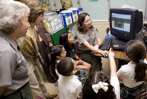 Laura Bush and Fran Mainella look on as students of Stella Summer’s Gifted Science class work with Ranger Maria Beotegui Thursday, Feb. 16, 2006, to navigate through Web Rangers, the online version of Junior Rangers, during a visit to Banyan Elementary School in Miami, FL. The National Junior Ranger Programs promote knowledge of science, history, the environment and learning through fun. White House photo by Shealah Craighead
