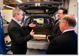 President George W. Bush views a hybrid vehicle powered by Lithium-ion batteries during a tour by Johnson Controls' CEO John Barth, far right, and employee Mike Andrew at the Johnson Controls' Battery Technology Center in Glendale, Wisconsin, Monday, Feb. 20, 2006. White House photo by Eric Draper