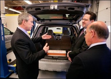 El Presidente George W. Bush examina un vehículo operado con baterías de ión de litio durante una gira el lunes, 20 de febrero de 2006 con el CEO de Johnson Controls, John Barth, derecha, y el empleado Mike Andrew en el Centro Tecnológico de Baterías de Johnson Controls en Glendale, Wisconsin. Foto por Eric Draper de la Casa Blanca