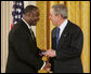 President George W. Bush congratulates Steve Ellis of Carrollton, Texas, upon receiving the President's Volunteer Service Award during a White House celebration of African American History Month. White House photo by Paul Morse