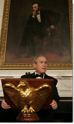 President George W. Bush, standing beneath a painting of President Abraham Lincoln, Sunday evening, Feb. 26, 2006 in the State Dining Room of the White House, welcomes guests to the State Dinner for the nation's governors.  White House photo by Kimberlee Hewitt